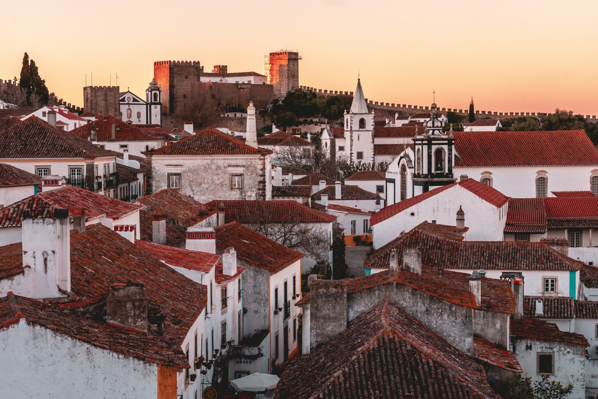 Pôr do sol sobre os telhados e o castelo da vila medieval de Óbidos, GoÓbidos